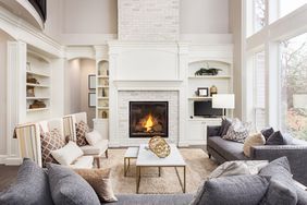 Beautiful living room interior with tall vaulted ceiling, loft area, hardwood floors and fireplace in new luxury home.