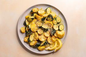 sliced roasted squash with parmesan and lemon on serving plate