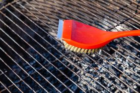 cleaning bbq grill with red wire brush