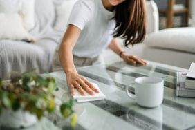 woman cleaning table in living room