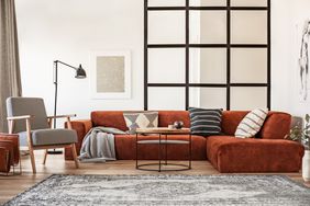 orange sofa in living room with pillows and cushions