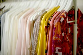 clothing hung on white hangers by color
