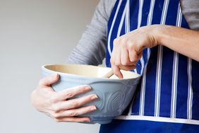woman using spoon to mix butter and sugar