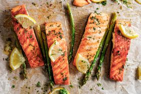 Baked salmon and green asparagus with aromatic herbs and lemon slices