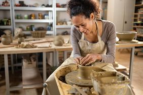 Female potter making ceramic vase on potter's wheel