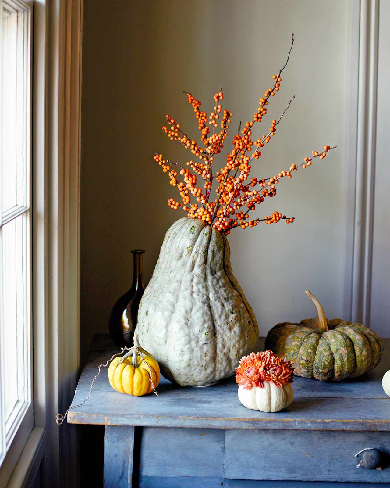 squash pumpkin fall floral arrangement near window