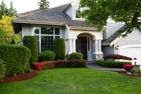 landscaped home with shrubs in front