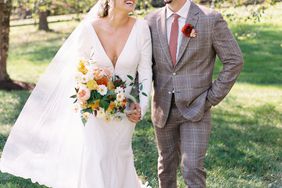 bride and groom smiling holding hands walking through yard