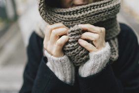 woman's hand holding knitted scarf