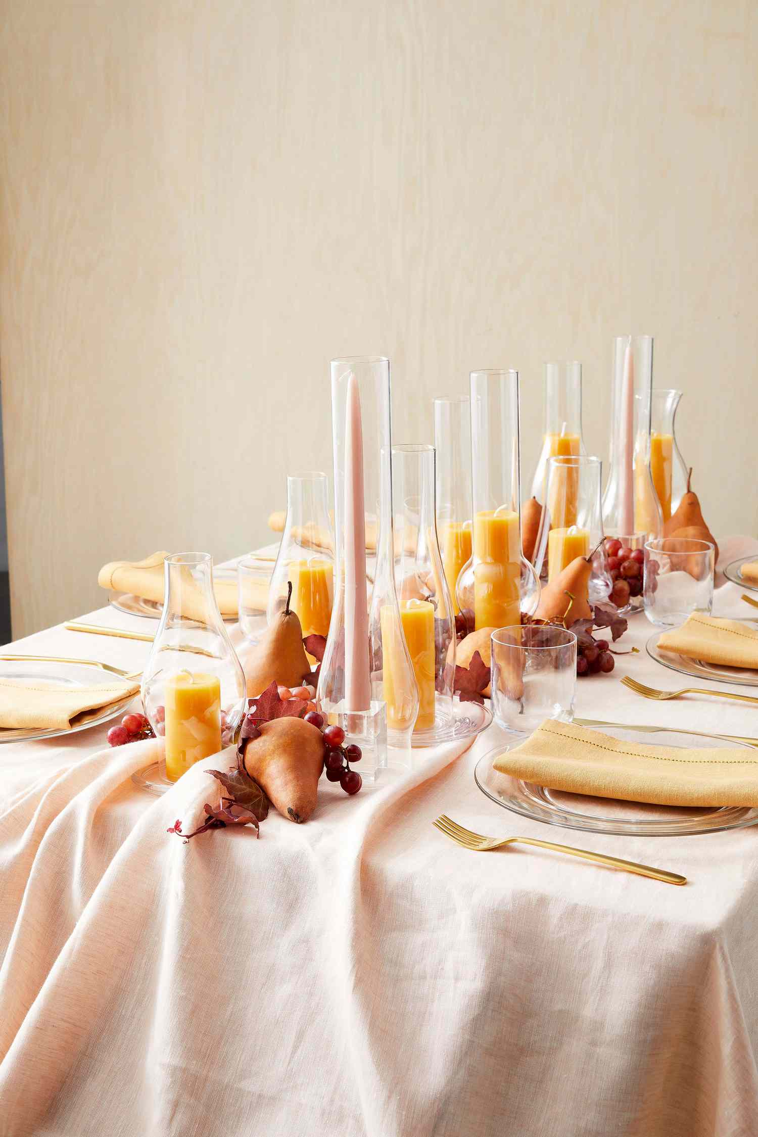 table decorated with candles in glass lamp chimneys and fruit