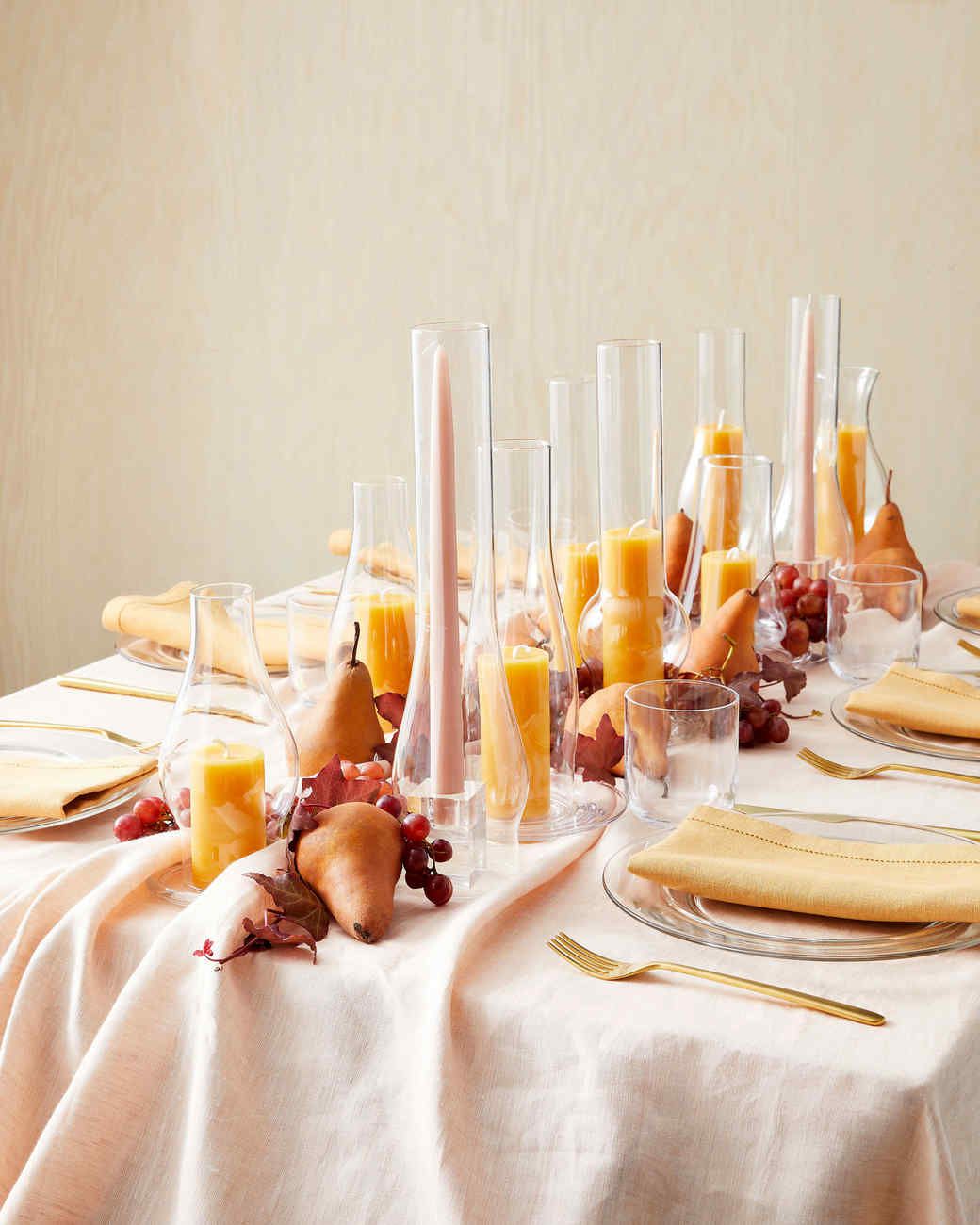 table decorated with candles in glass lamp chimneys and fruit