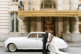 wedding couple kissing in front of vintage car