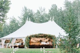 wedding reception underneath white sailcloth tent in forest