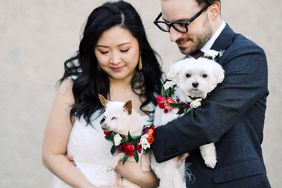 bride and groom holding their dogs