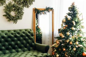 Green themed holiday decor with velvet couch, wreaths and christmas tree