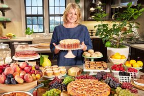 martha in kitchen holding cake surrounded by desserts