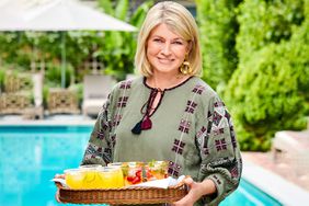 Martha Stewart standing by pool holding cocktail tray