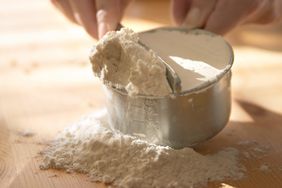 discarding extra flour from measuring cup