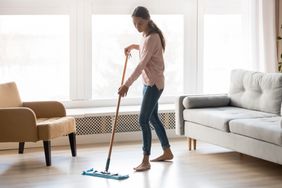 woman mopping living room with hard wood flooring