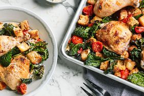 plate and sheet of chicken and kale dinner on marble table top
