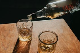 pouring scotch whiskey into rocks glass