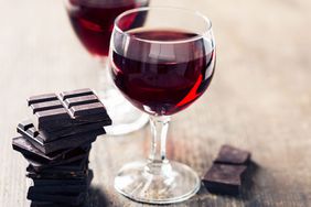 glass of red wine and pieces of dark chocolate on table