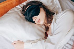 woman sleeping on silk pillowcase wearing eye mask