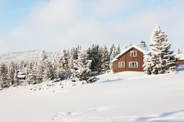 Landscape of log cabin surrounded by snow
