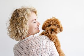 woman hugging toy poodle dog